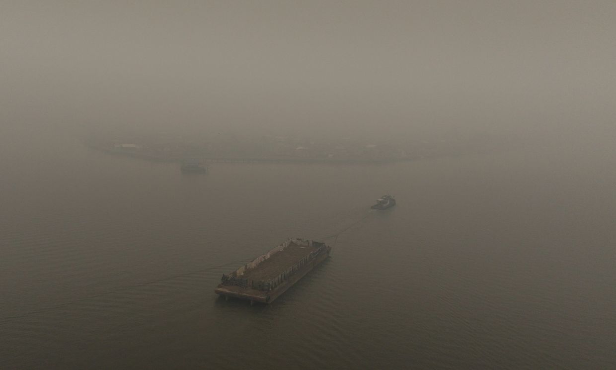 A drone view shows a barge being towed along the Kapuas River, shrouded in haze from wildfires, in Pontianak, West Kalimantan province, Indonesia, Sept 15, 2026. - Photo: Reuters