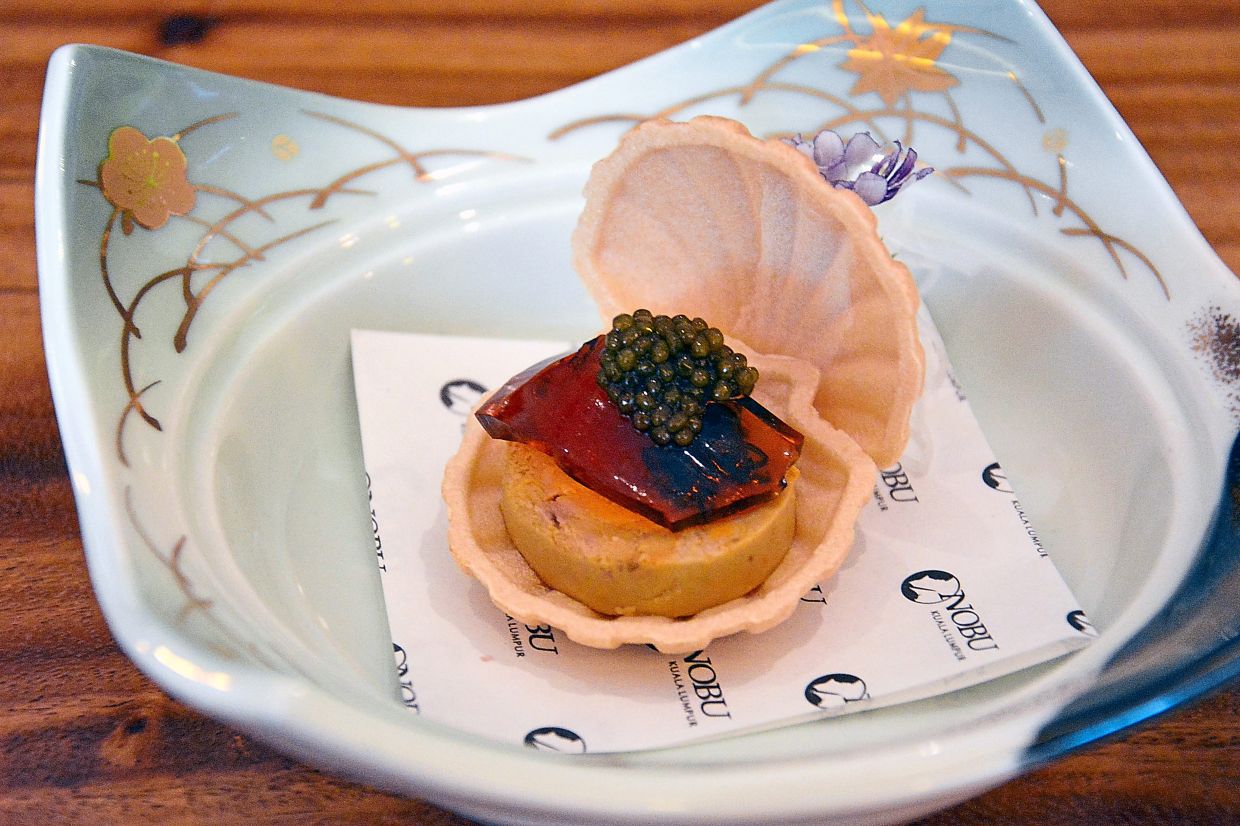 Monkfish liver presented on a clam-shell cracker.