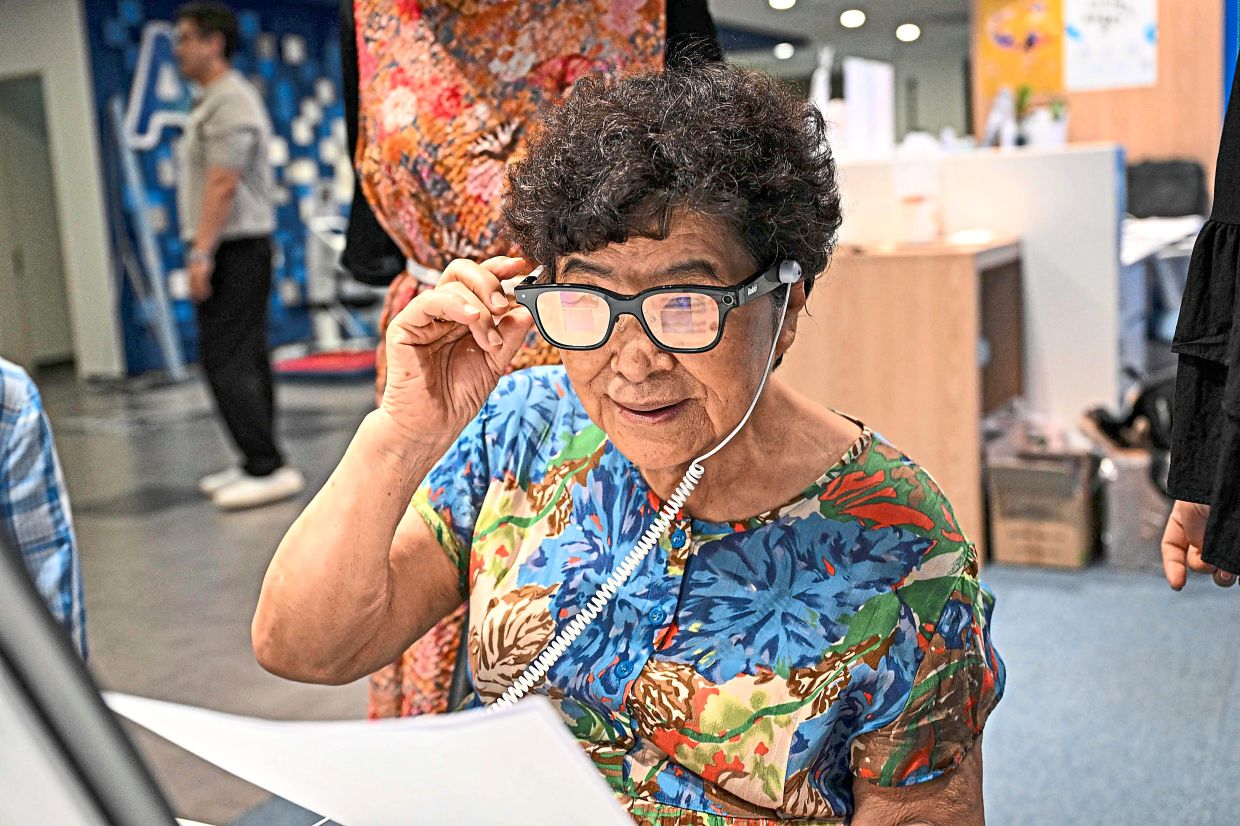 Future ready: An elderly woman trying on a pair of Rokid AI glasses at Seoul Open City University in Seoul. — AFP