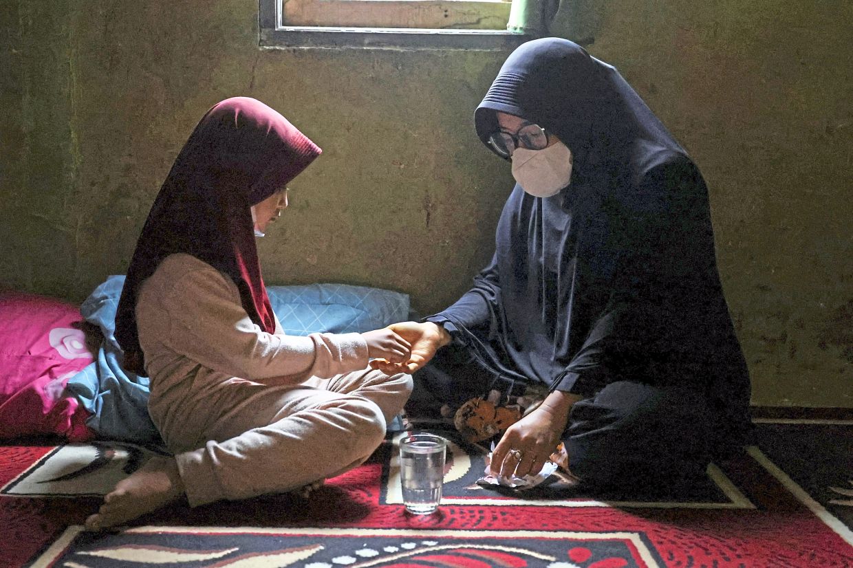 Sick of feeling sick: Mimi giving medicine to her daughter inside their home amid haze from wildfires in Kubu Raya, West Kalimantan. — Reuters