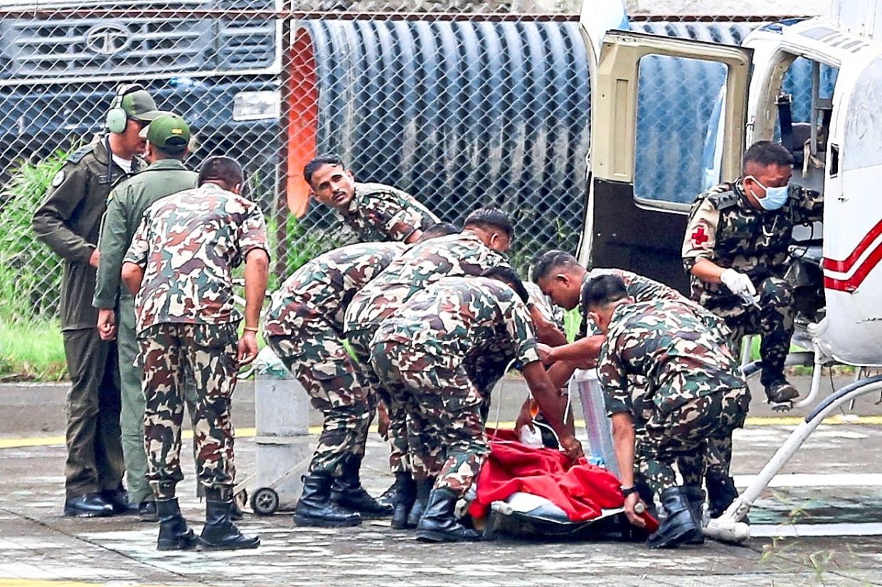 Members of the Nepal Army moving Maharjan, who was rescued from a tunnel at the Upper Trishuli 3A hydropower project, after he was airlifted from an army base in Nuwakot to Kathmandu. — Reuters