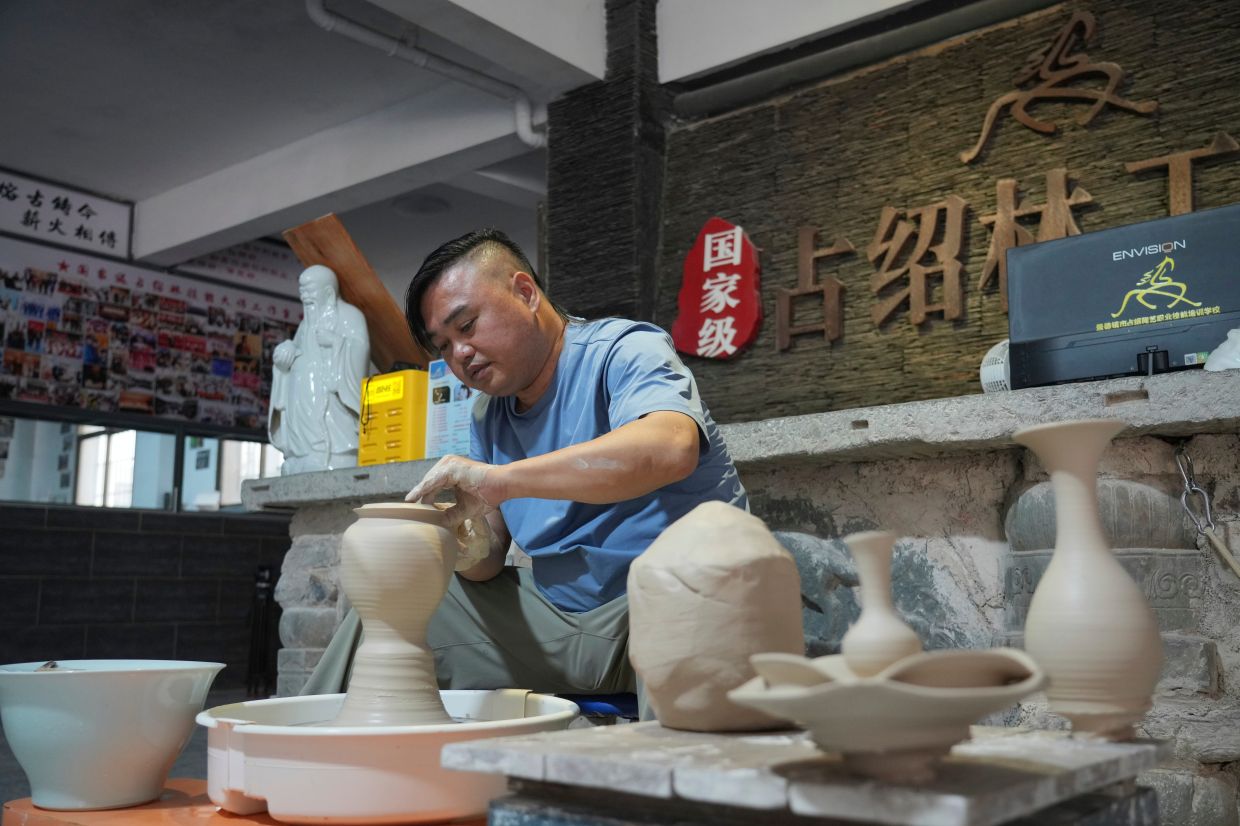 Chinese ceramic wheel-throwing artist Zhan Shaolin demonstrates his craft in Jingdezhen.