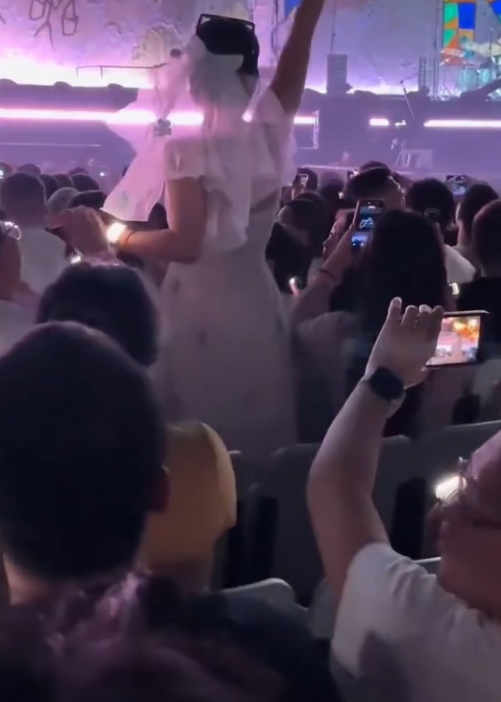 The person who recorded the clip noted that the couple remained standing for over five minutes, leaving those behind them completely unable to see the stage. - Weibo
