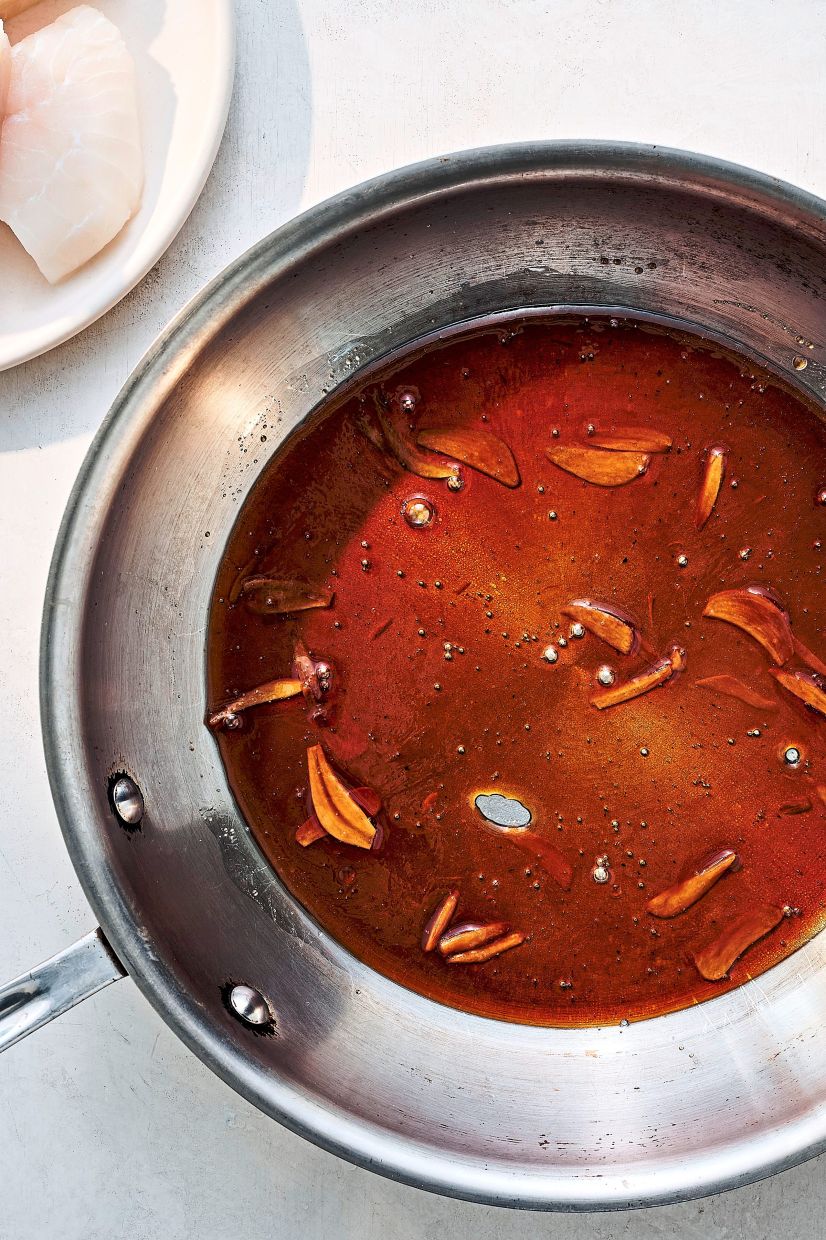 Sugar, oil and garlic are cooked together to create a sauce for caramelised garlic fish.