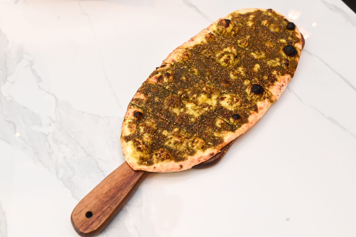 Saj zaatar is a delicious, incredibly addictive street food staple in the Arab world that is made up of flatbread topped with zaatar.