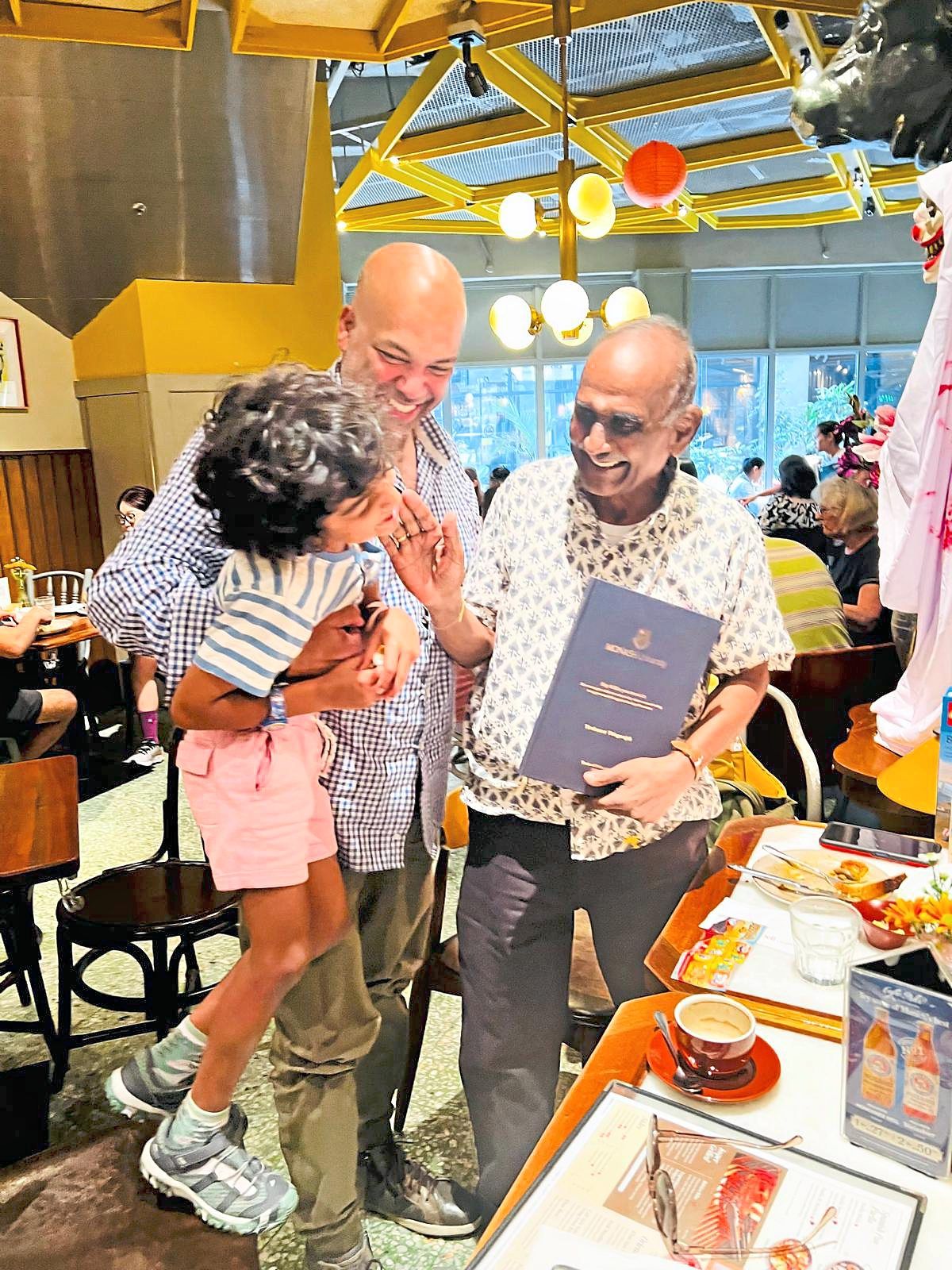 At a recent meetup with his former teacher Govind (right), the author (centre) was proud to introduce him to his son.