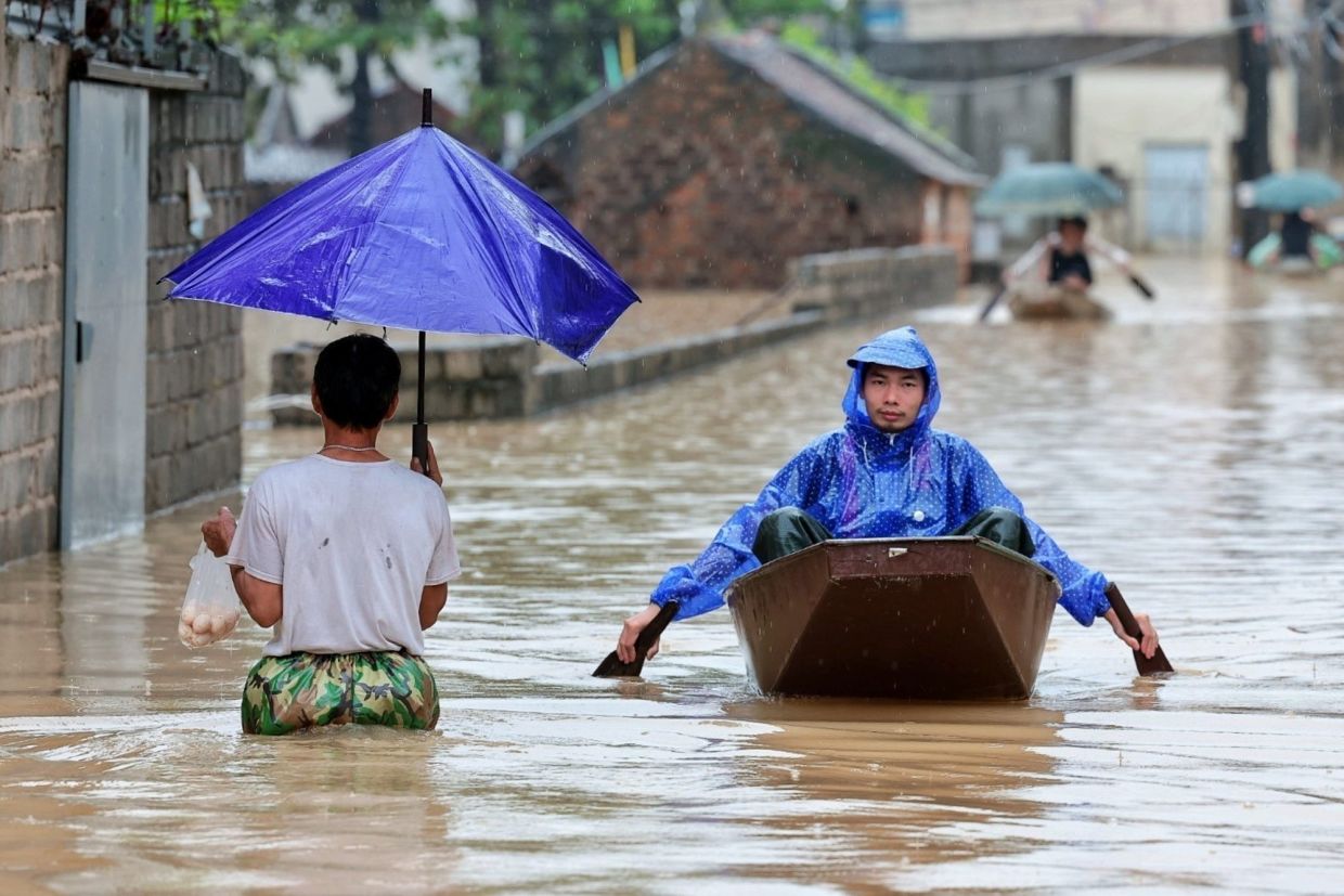Local residents commuing by boat through a flooded village on the outskirts of Hanoi, Vietnam on Sept 17, 2026. - AP