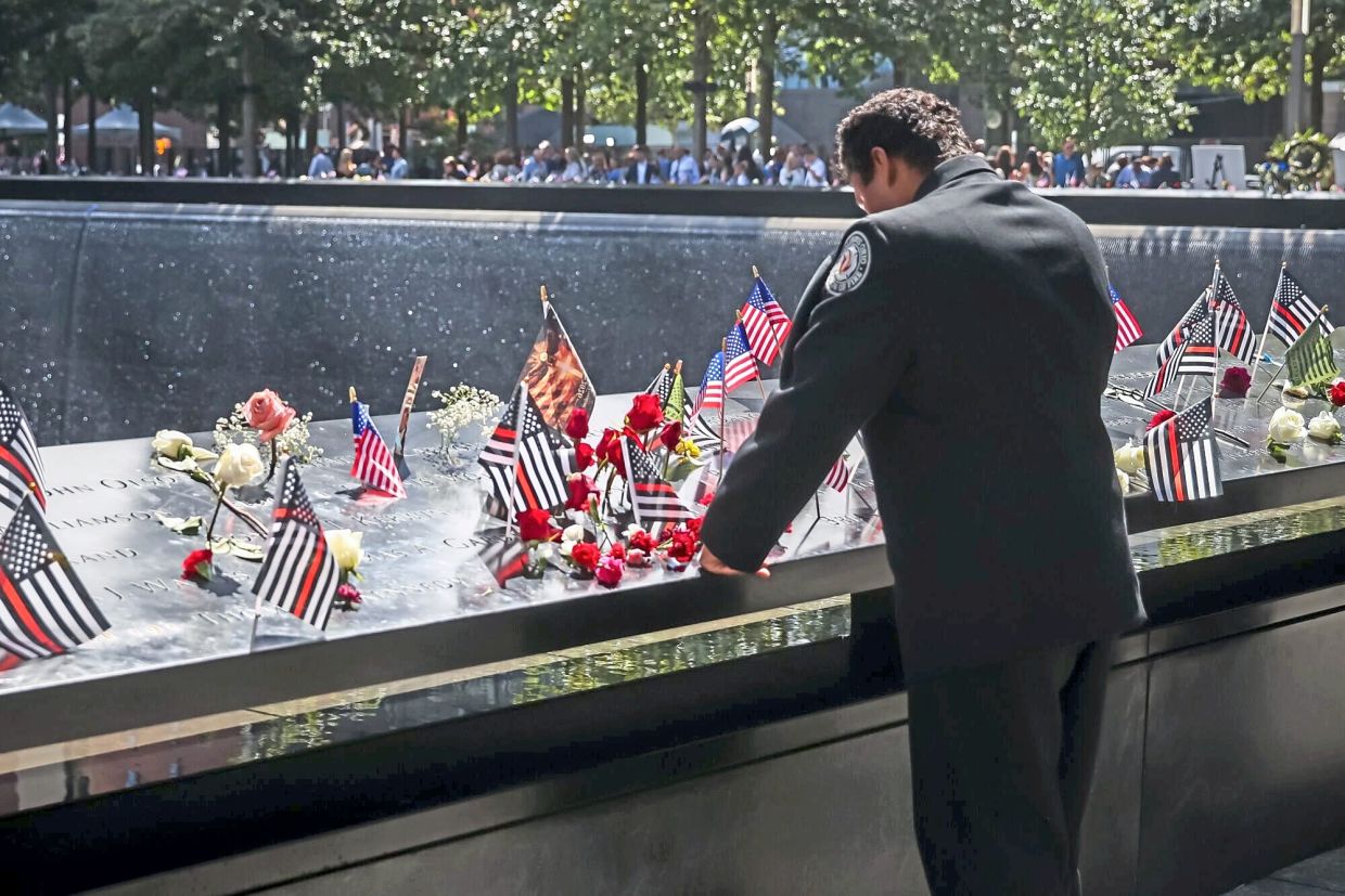 An attendee visits the South Tower reflecting pool during the 25th anniversary commemoration ceremony at the National 9/11 Memorial and Museum. — Bloomberg