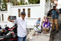 Najib's supporters gather outside his house in anticipation of his return