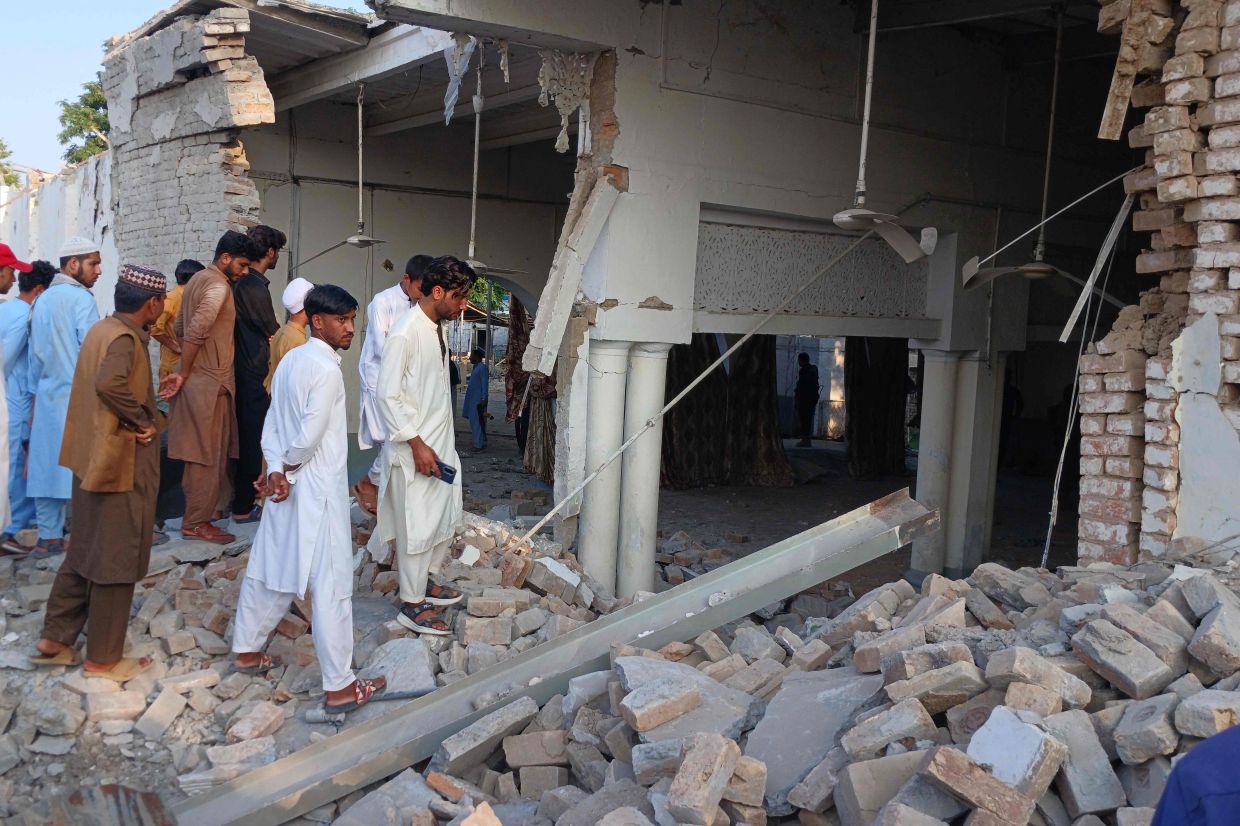 Onlookers gather at the site of an explosion inside the police headquarters at Kohat in Pakistan's Khyber Pakhtunkhwa province on September 18, 2026. An explosion at a historic police headquarters in northern Pakistan on September 18 killed at least eight people and wounded 35 more, officials said, with the country's president swiftly blaming a militant group. - Photo: AFP