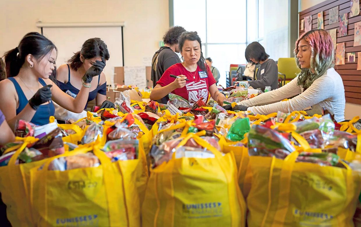 Volunteers at the Chinatown Branch Library packing fresh produce and food to people in need throughout the neighbourhood.