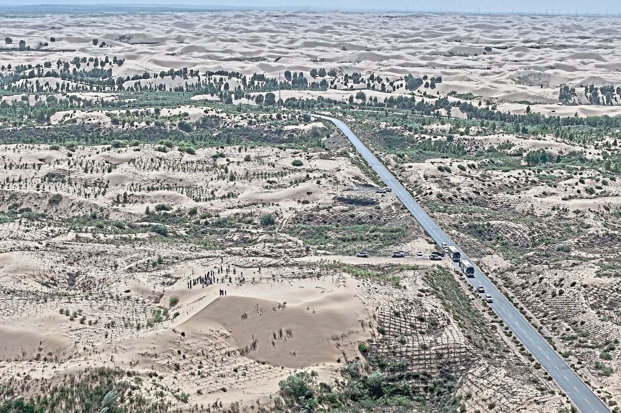 A highway cuts through a desertification control site of the Engebei Ecological Area.