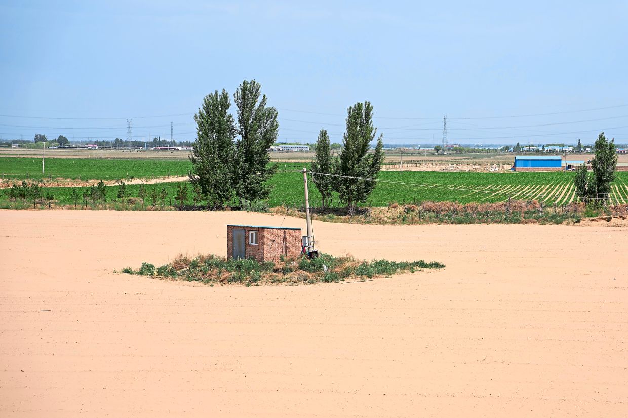 A shed is surrounded by a sandy plain near Ordos.