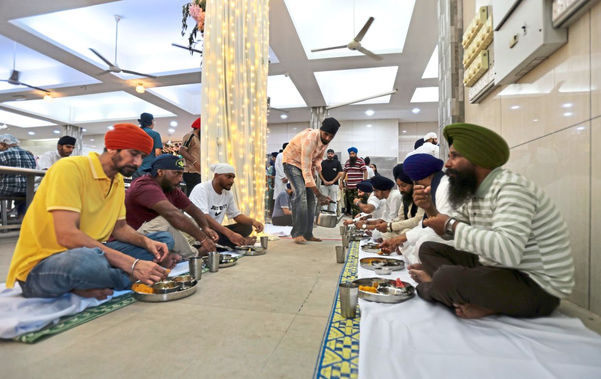 The Sikh community and visitors alike enjoying a meal at the newly restored gurdwara.