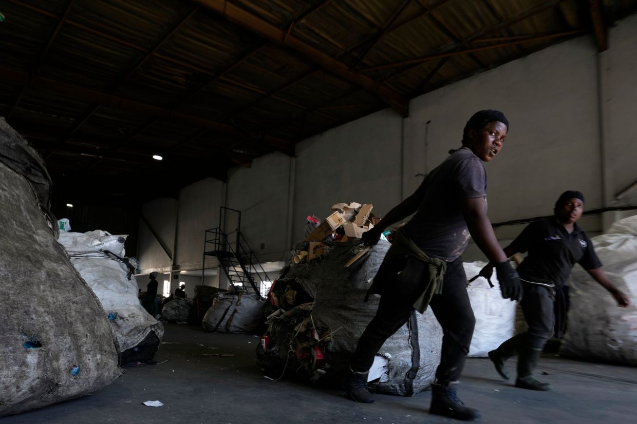 Workers pull garbage containing recyclable items at the Whole Earth Recycling in Johannesburg.