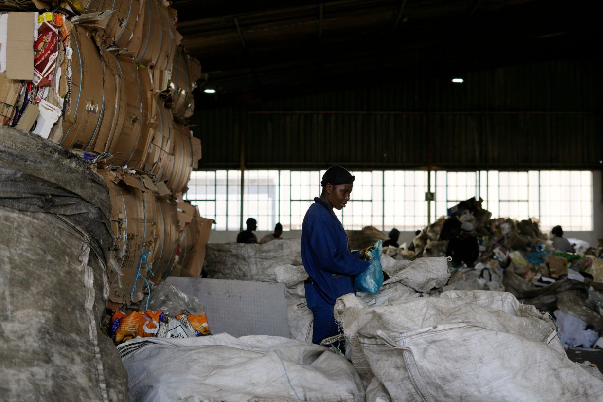 A worker sorts recyclable items in a pile of garbage at the Whole Earth Recycling in Johannesburg.