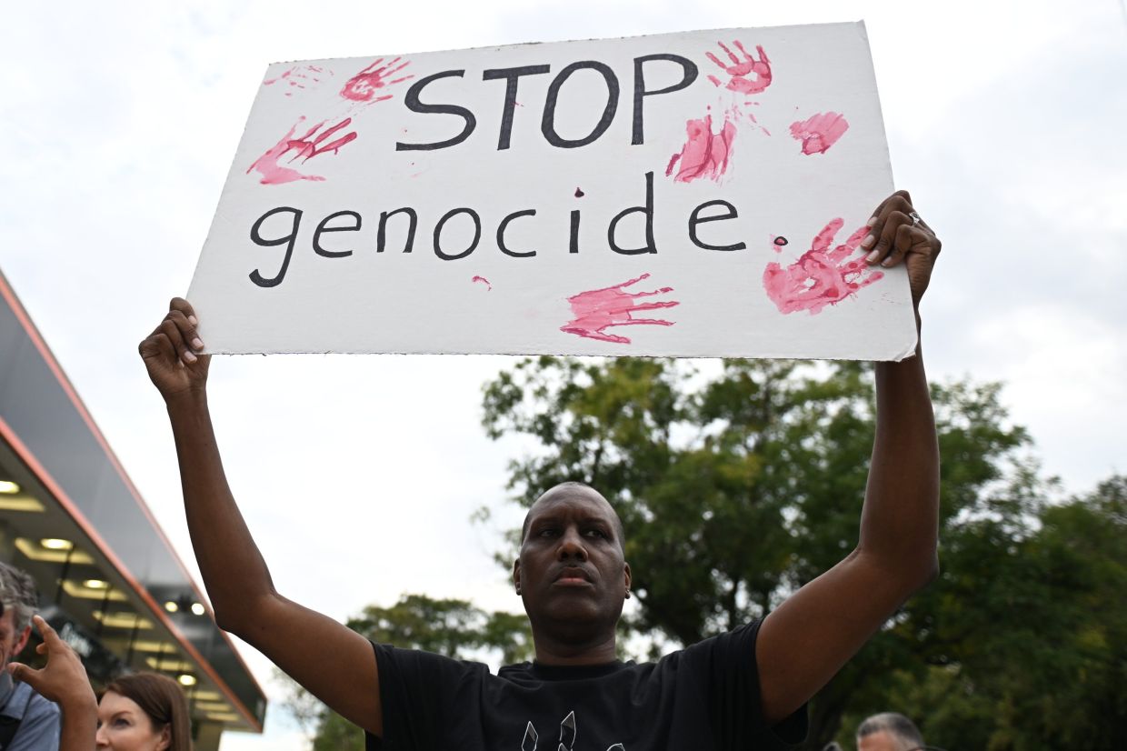 A pro-Palestinian demonstrator holds a sign prior to a protest before an Ed Sheeran concert in Philadelphia, Saturday, Sept 19, 2026. Photo: AP