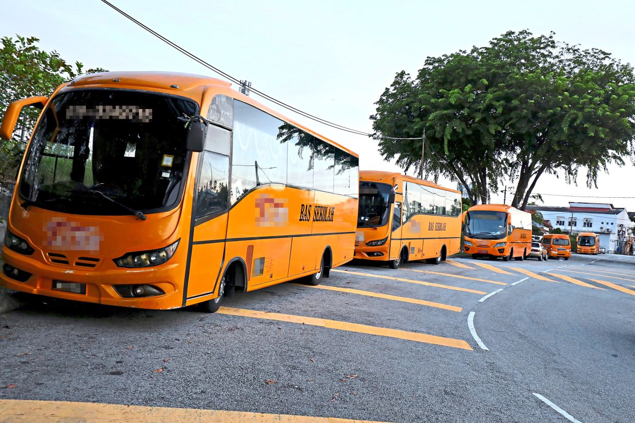 School vans parked near a residential road in Taman Bukit Indah.