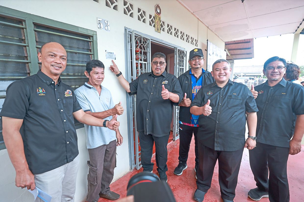 Ab Rauf with a homeowner during the Kampung Digital initiative visit. Thousands of homes and premises throughout the state have benefited from the programme, which introduced digital addresses to make them easier to identify and locate.