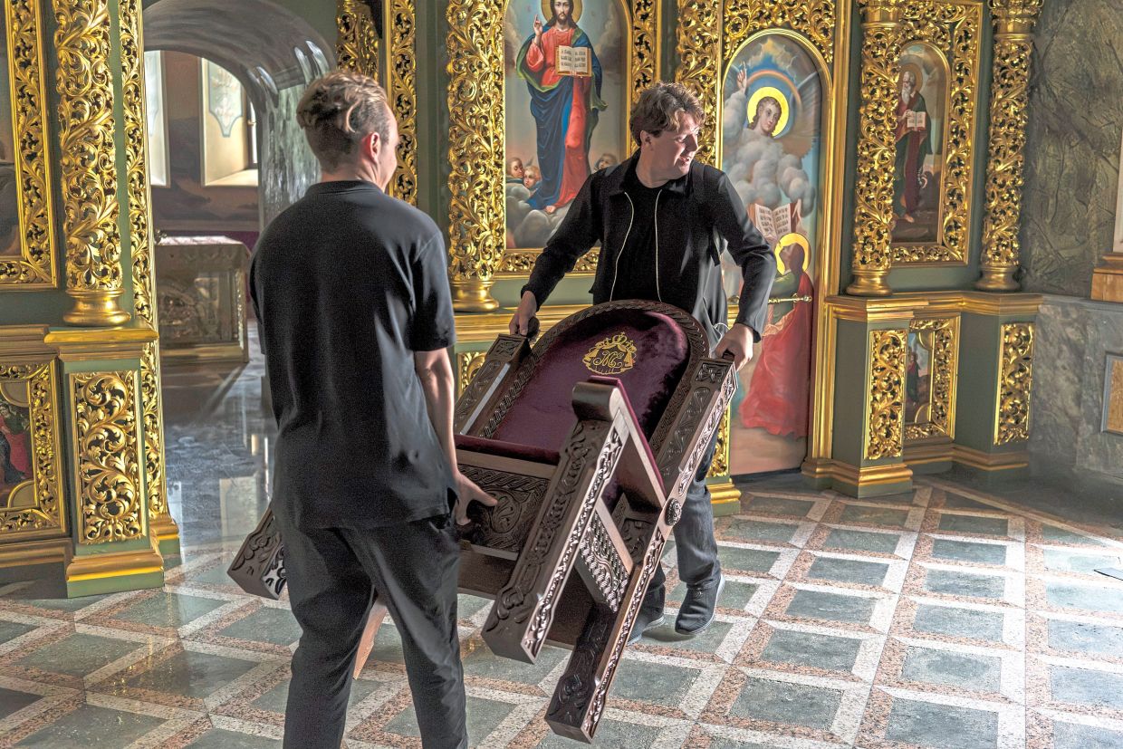 People carrying a chair into the cathedral. — Photos by Brendan Hoffman/The New York Times