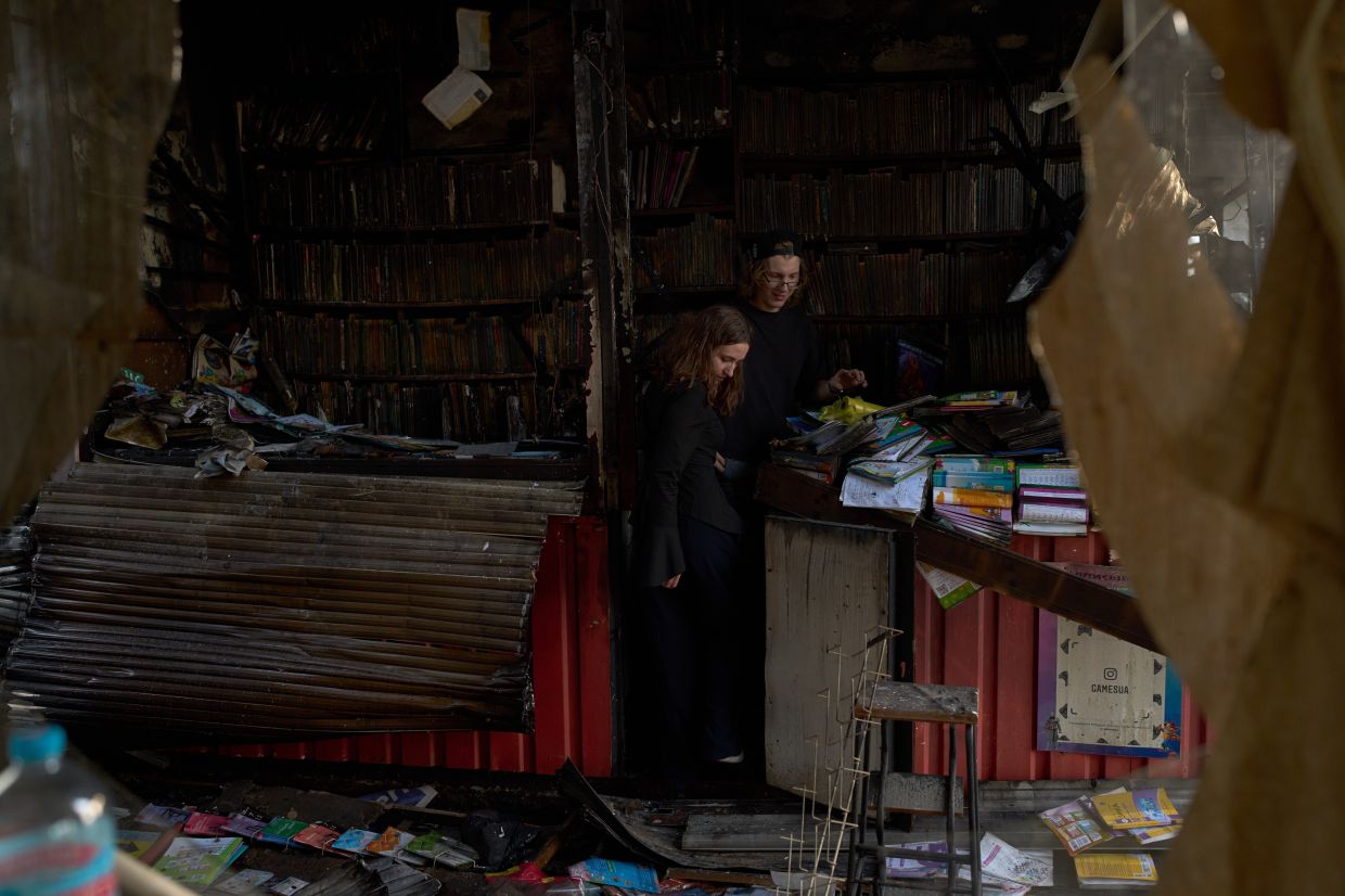 People view damage the day after a Russian missile attack at a city book market in Kyiv, Ukraine on Aug 17. Photo: AP