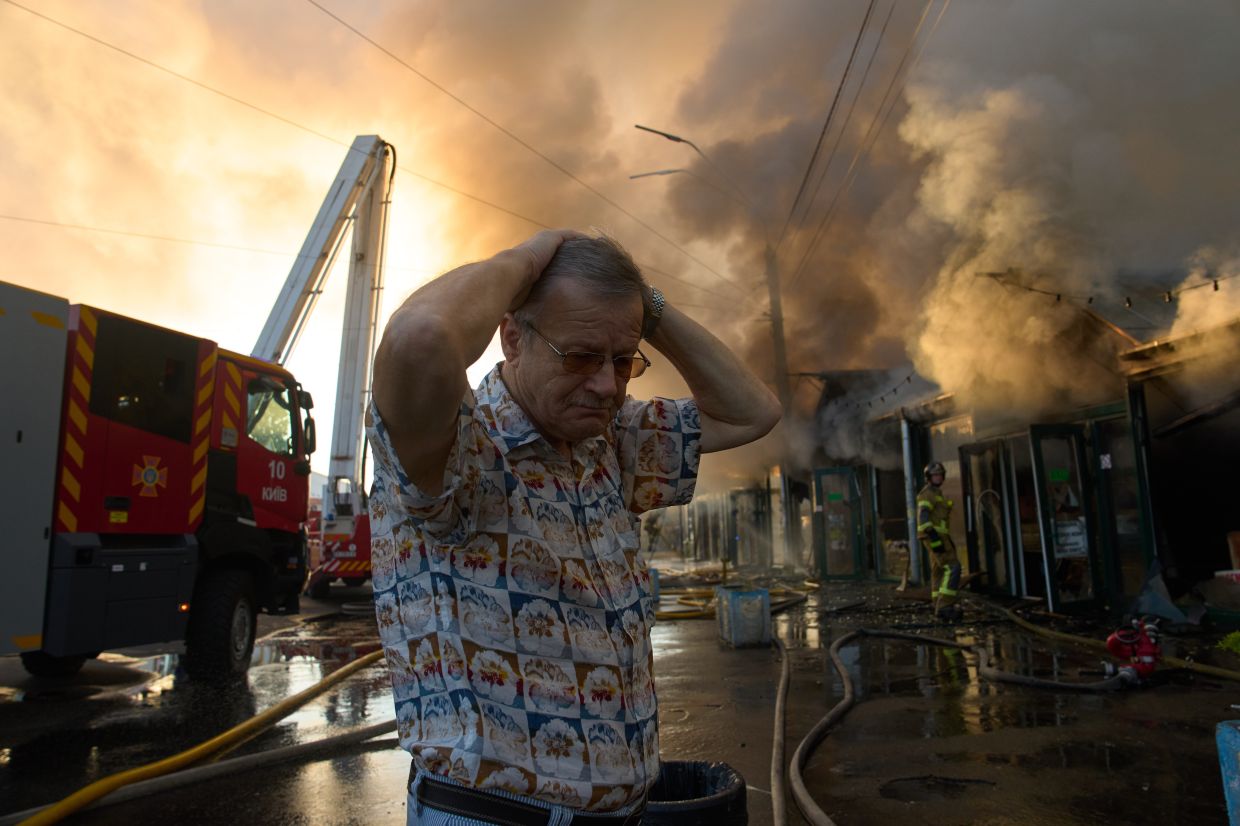 Bookseller Alexander Bahlai reacts as firefighters try to put out a fire at a city book market following a Russian missile attack in Kyiv, Ukraine on Aug 16. Photo: AP