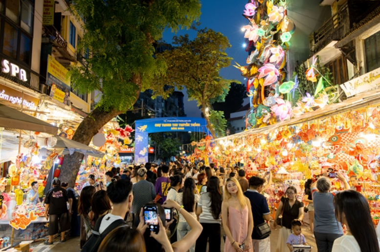 Crowds inch their way through the brightly lit Hang Ma Street, reflecting the immense popularity of this seasonal cultural hub. VNS