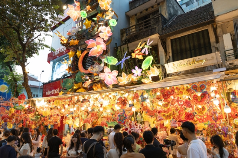 The lively shopping atmosphere along Hanoi's Hang Ma street, with oversized festive decorations hanging above the vendor stalls as Vietnam prepares to celebrate the Mid-Autumn Festival on Sept 25. - VNS