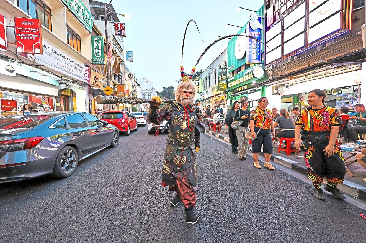 A performer dressed as legendary Chinese mythical figure Sun Wukong, also known as Monkey King, walking along Jalan Sultan.