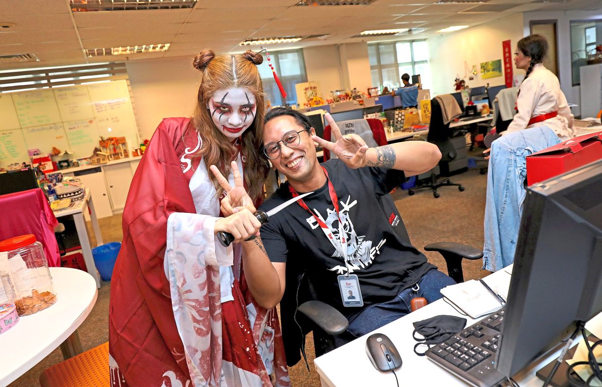 A staffer smiling next to one of the characters from NOF12.