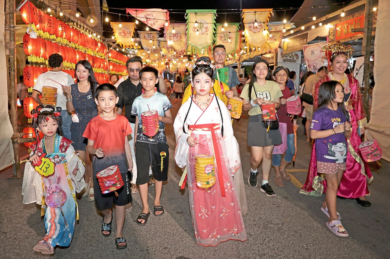 Local families, including businessman Ng (in black shirt), his wife and children, enjoying the customary lantern walk during the Penang Mid-Autumn Festival 2026. Some, including Ng’s daughter Stella (far left) came dressed as the moon goddess Chang Er, a key character in the Mid-Autumn lore.
