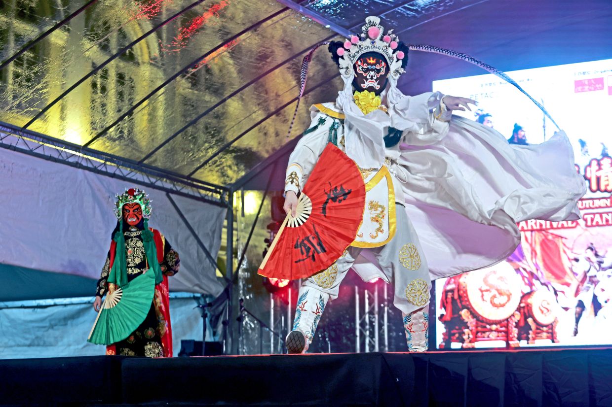 Performers from the Penang Nasi Lemak Face-Changing Troupe entertaining crowds with their rapid mask switches.