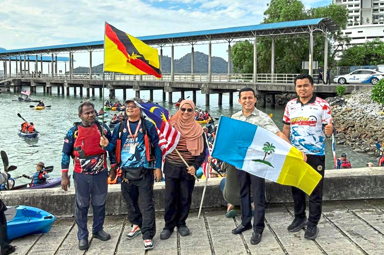 Wan Nur Iza (centre) and representatives of the Batu Uban Marine Police and KBKU flagging off the kayak challenge. — Photos: Handout