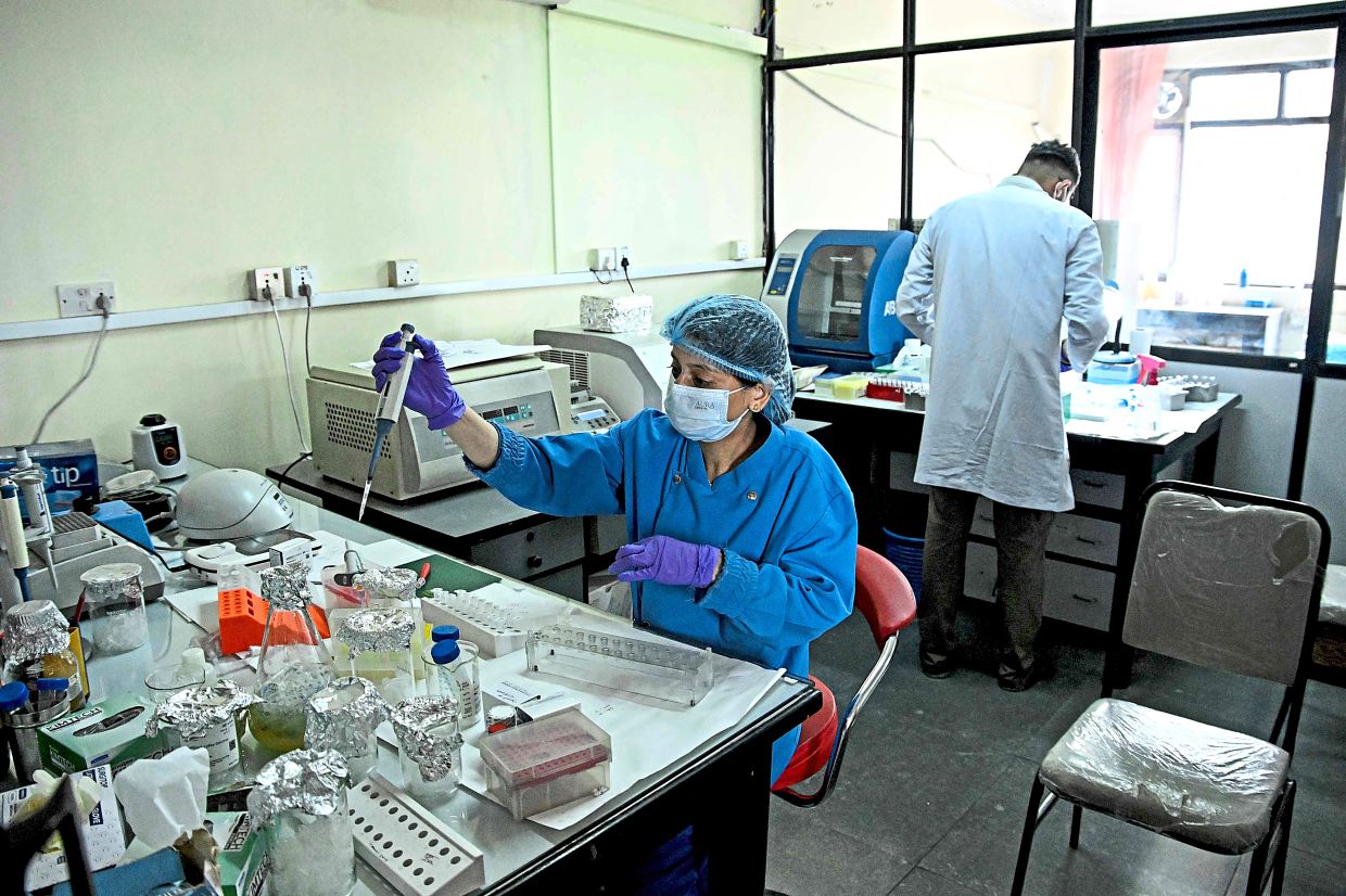A forensic analyst conducting DNA testing to help identify missing victims at the National Forensic Science Laboratory in Lalitpur, Nepal. — AP