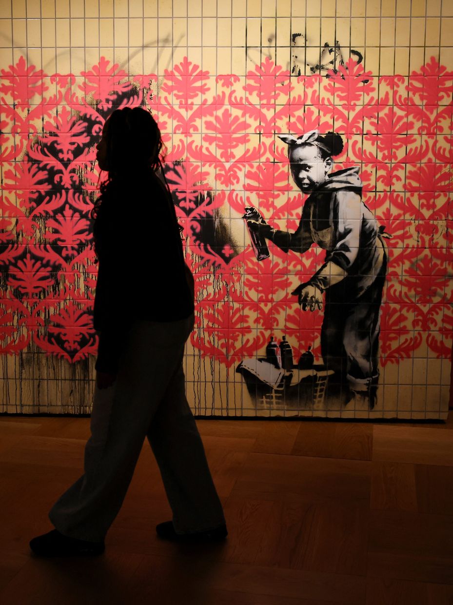 A visitor walks by a Banksy piece at the Lucas Museum of Narrative Art in Los Angeles. Photo: Reuters 