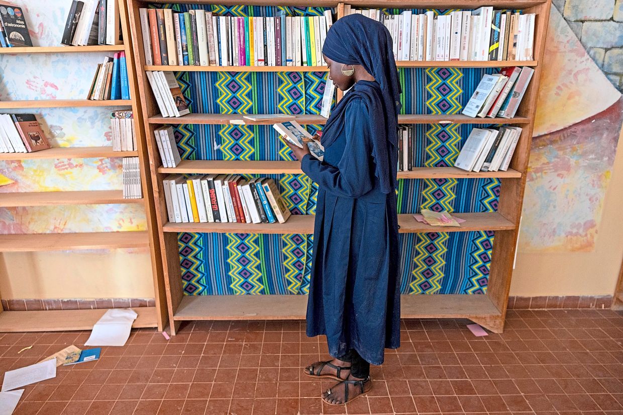 Ndeye Awa browses the shelves of the Mariama Ba school library. Photo: Caitlin Kelly/AP