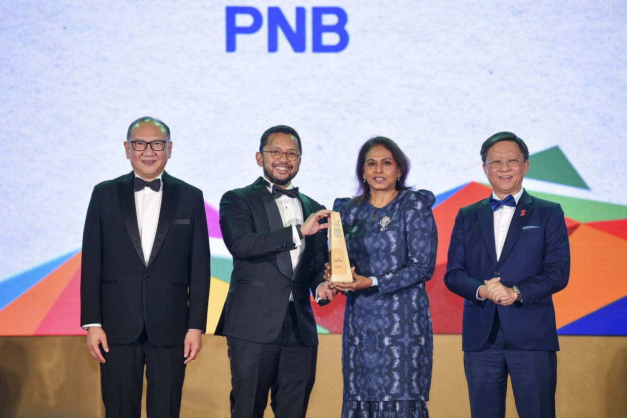 PNB won gold in Others –Transformation and silver in Social – Good Health and Wellbeing at The Star’s ESG Positive Impact Awards 2024. PNB group chief corporate affairs officer Nimmi Kamal (second from right) and corporate sustainability and stewardship head Muazzam Mohamad (second from left) receiving the trophy from Star Media Group Bhd group chief executive officer Chan Seng Fatt (right) and OCBC Malaysia chief executive officer Tan Chor Sen. — IZZRAFIQ ALIAS/The Star