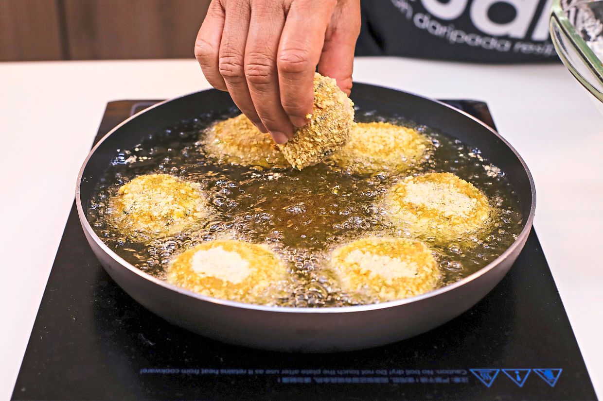 Gently drop the sardine cutlets in hot oil and fry until golden brown.