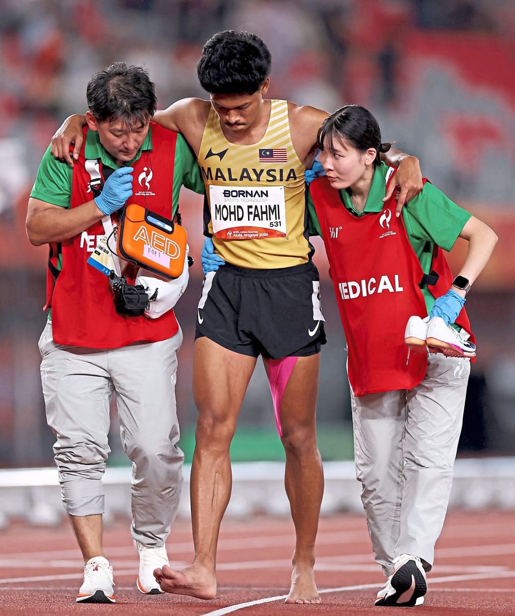 Tough luck: Mohd Azeem Fahmi receiving medical attention after sustaining an injury. — Reuters