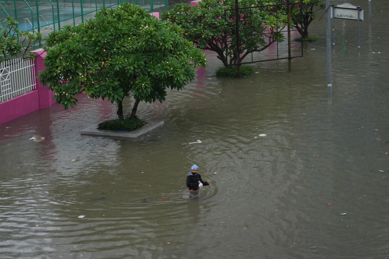 Man wades through floodwaters after heavy rain in Bangkok, Thailand, on Saturday, Sept. 26, 2026. -- AP Photo/Sakchai Lalit