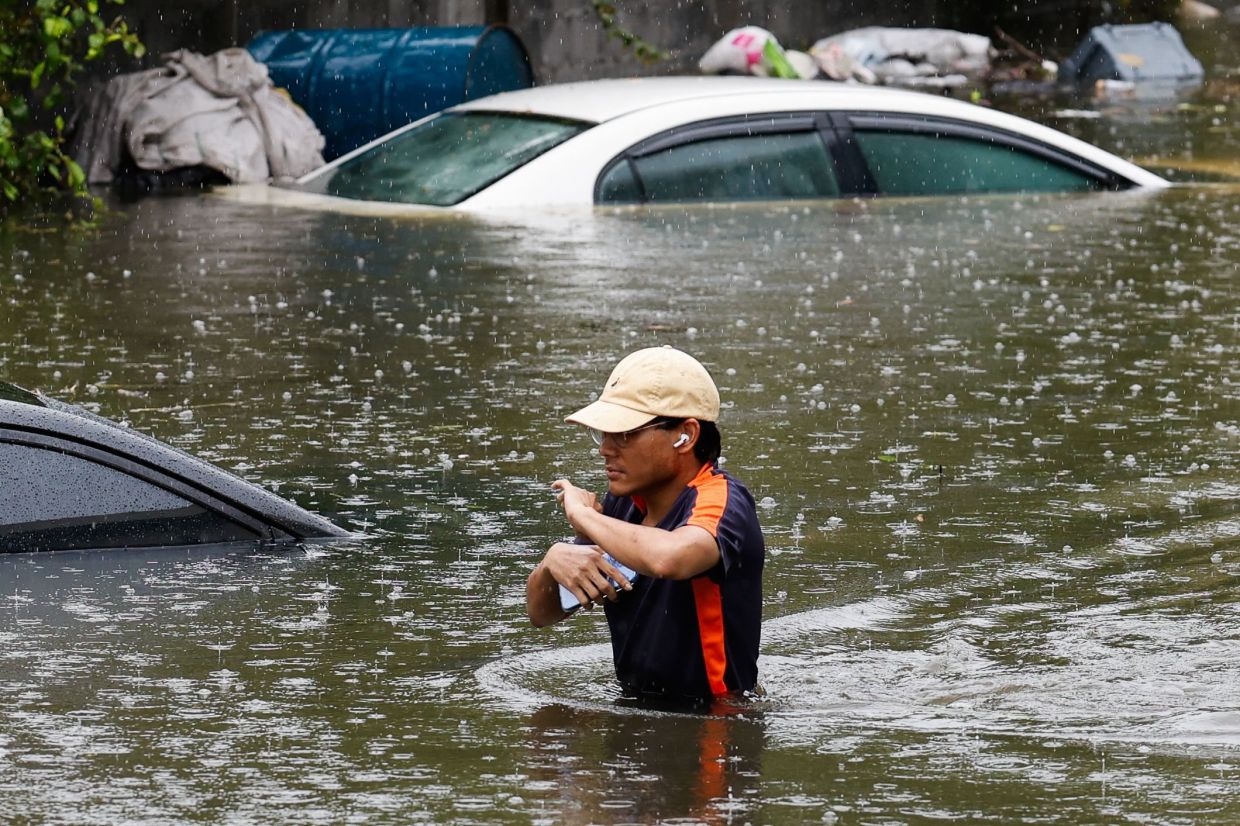 A man walks through flood waters after heavy rain in Bangkok on September 26, 2026. Bangkok authorities declared a flood disaster across the Thai capital on September 26 after almost 48 hours of heavy rain left canals full, roads submerged and residents knee-deep in water. - Photo: AFP