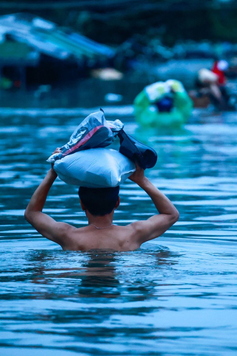 A man wades through a flooded street during heavy rain in Bangkok, Thailand, Sept 26, 2026. - Photo: Reuters