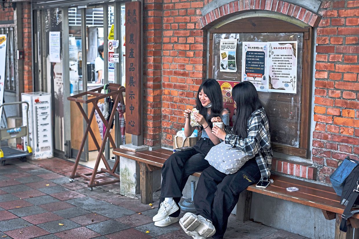 People sit outside the Agricultural Products Sales Center at National Taiwan University in Taipei. The centre specialises in dairy products like ice cream sandwiches. Photo: The New York Times/An Rong Xu