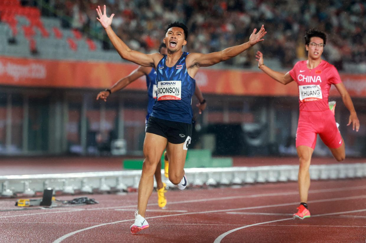 Thailand's Puripol Boonson (L) and China's Huang Youwen react after crossing the finish line in the men's 200m final. - AFP