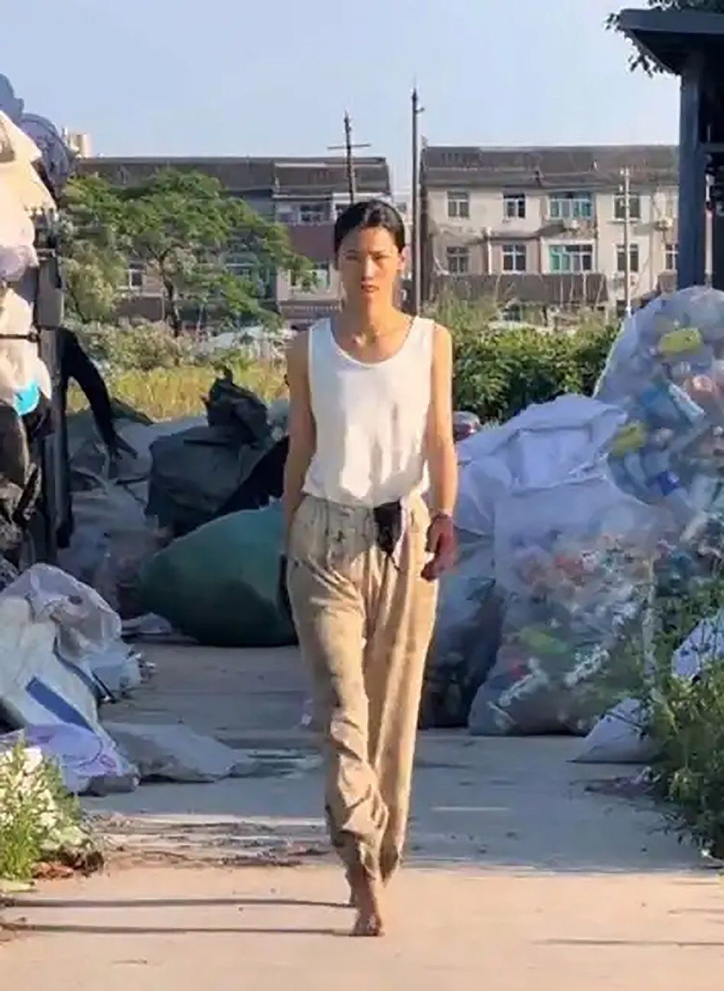 Internet users were captivated by how her tall, slim figure and chiselled features contrasted sharply with her dirt-stained work clothes and the surrounding refuse. --Photo: Baidu