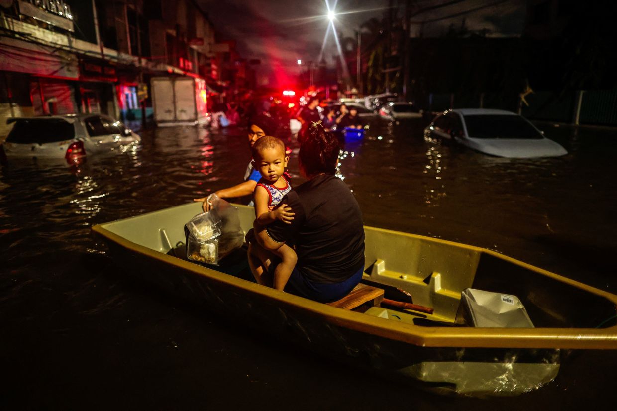 People are transported by boat in a flooded area during heavy rain in Bangkok, Thailand, on Sunday, September 27, 2026. Photo: REUTERS/Patipat Janthong