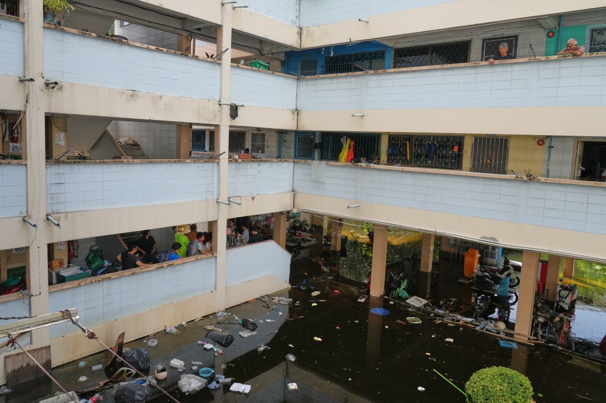 Residents of a building looking out at the flooded streets in Bangkok on Sept. 29, 2026. - AP