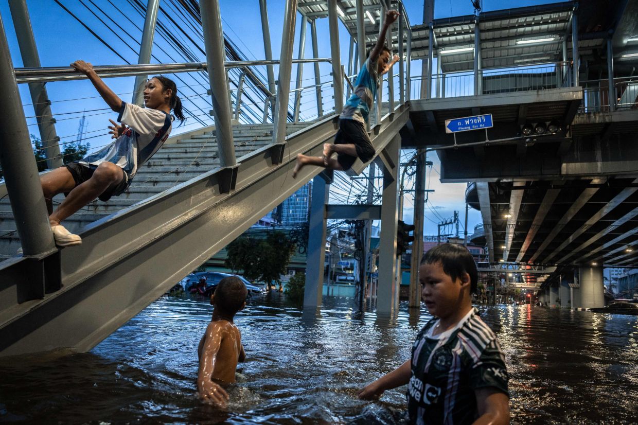 Children playing in the floodwater in the Bang Kapi district of Bangkok on Sept 28, 2026. - AFP