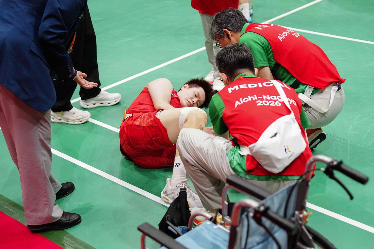 China's Liu Shengshu (C) receives medical attention after she and Tan Ning lost against South Korea's Lee So-hee and Baek Ha-na in the women's doubles badminton final. - AFP