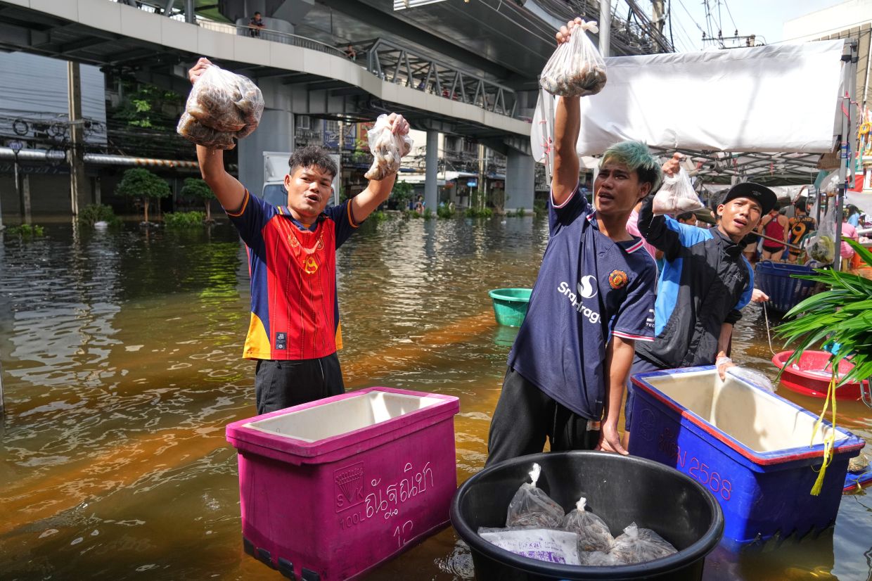 Vendors sell food Iitems in floodwater after heavy rain in Bangkok, Thailand, Tuesday, Sept 29, 2026. - Photo: AP